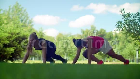 户外运动的女人两个女人在健身前在绿草上热身视频的预览图