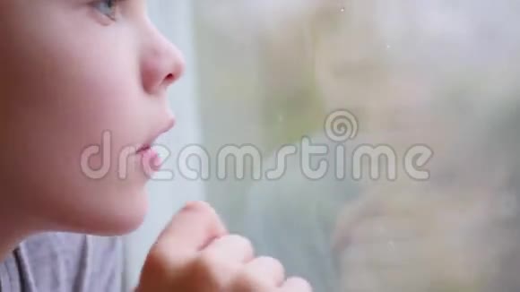 孩子在窗户玻璃上画一个手指外面的雪模糊了视频的预览图