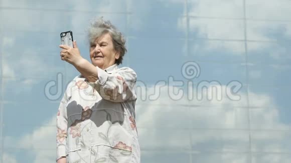 成熟的老妇人用智能手机拍照视频的预览图