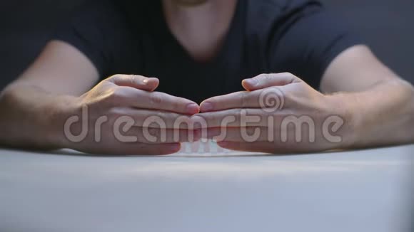 男人的双手在灰色背景下显示由白色字母组成的单词家族视频的预览图