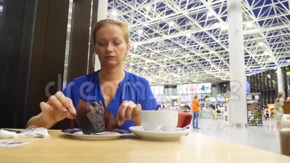 女士在机场候机室使用智能手机她喝咖啡对机场飞行的期望4k慢动作视频的预览图