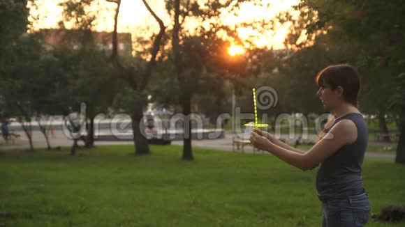 夏天日落时妈妈和女儿在公园的草地上玩耍视频的预览图