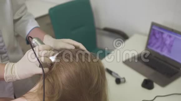皮肤科医生检查女孩头部的皮肤视频的预览图