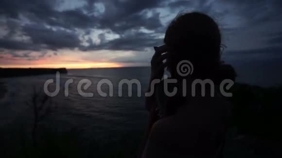 在海滩上看日落的女人视频的预览图