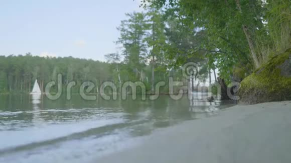有白色船底的湖岸划艇漂浮停泊在岸外在一个完美的倒影湖上视频的预览图