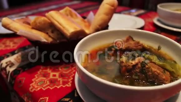 餐厅提供美味的阿塞拜疆国民羊肉汤面包背景上白色盘子里的肉视频的预览图