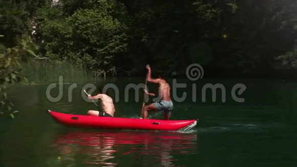 两个男性朋友骑着独木舟用桨把她们的女性朋友溅了起来视频的预览图