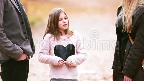 站在公园里和父母说话的女孩视频的预览图