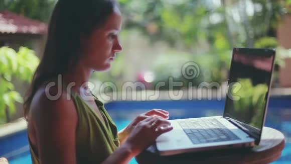 女商人在游泳异国情调的暑假在笔记本电脑上打字1920x1080高清高清视频的预览图