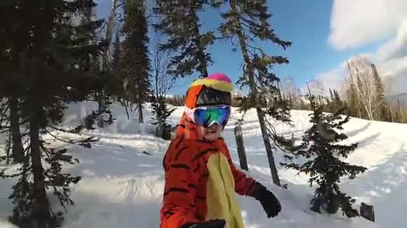快乐的女孩在滑雪板上滑下斜坡视频的预览图