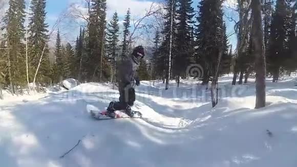 阳光明媚的一天滑雪板上一个快乐的家伙滑下山坡视频的预览图