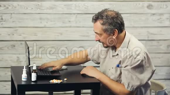 一个留胡子的人在电脑前工作咳嗽视频的预览图