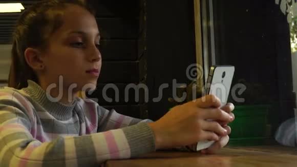 十几岁的孩子在看她的智能手机视频的预览图