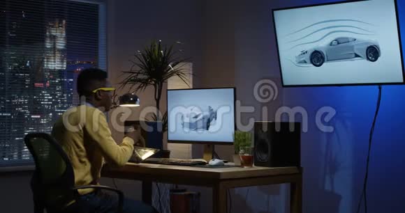 年轻人坐在后面在电脑上编辑图像视频的预览图
