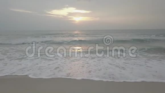 海滩上的日落宁静的田园诗般的景象金色的日落在海面上海浪慢慢地溅在沙滩上视频视频的预览图
