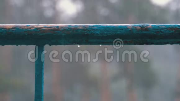 在下雨的街道背景下水滴滴在窗户阳台或栏杆上视频的预览图