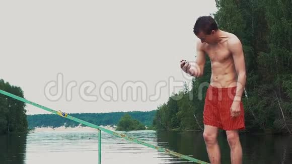 年轻人手里拿着一架高级摄像机在湖边奔跑夏天情绪视频的预览图