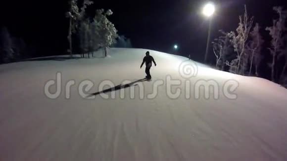 冬季夜晚男性滑雪者从山上滑下来滑雪板上的那个人正在从山上滑下来视频的预览图
