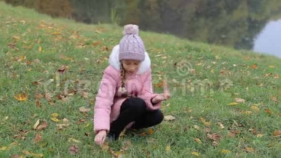 秋天公园里的小女孩可爱的小女孩微笑视频的预览图
