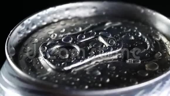 一杯冷饮在黑色背景下旋转苏打或啤酒铝罐上的水滴视频的预览图