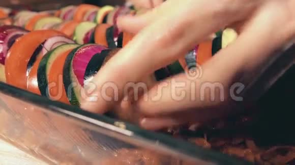 女人把切好的蔬菜放进玻璃锅里业余烹饪自制拉塔图耶4K视频视频的预览图