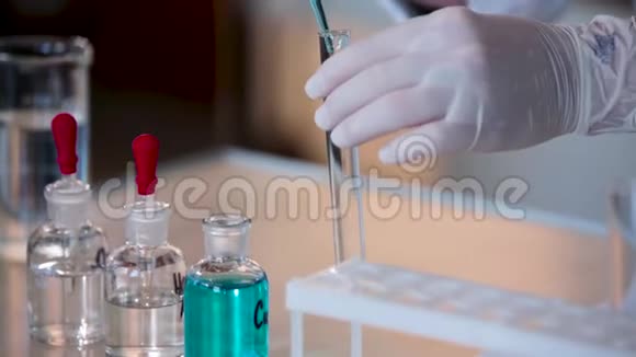 科学家将蓝色液体滴入试管的特写镜头把液体从吸管中倒入管子视频的预览图