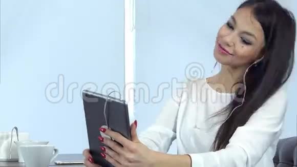 有魅力的年轻女性用平板电脑检查自己的化妆并准备视频通话视频的预览图