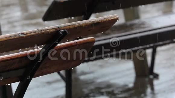 街咖啡厅和雨中的空凳慢动作视频的预览图