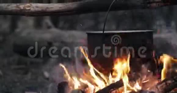 古老的复古营地平底锅开水为汤准备在森林的火夏季晚上的火焰篝火视频的预览图
