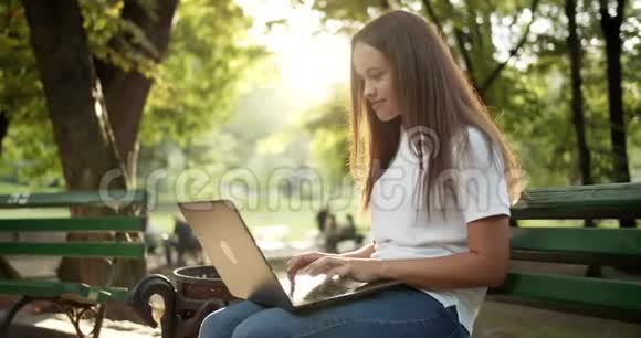 在公园的笔记本电脑上工作的女人视频的预览图