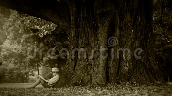 老电影效果片段小男孩坐在树下看书视频的预览图