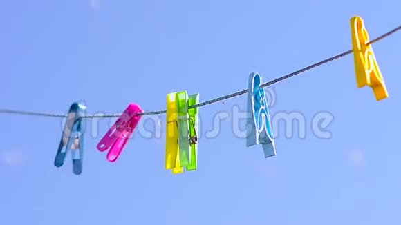彩色衣夹在晾衣绳上迎风蓝天视频的预览图