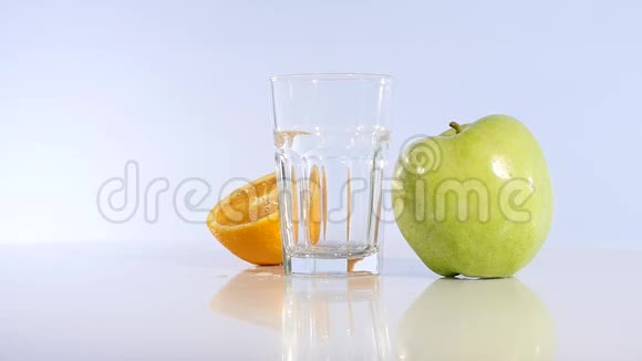 苹果汁和橘子倒入玻璃杯中苹果饮料新鲜苹果视频的预览图