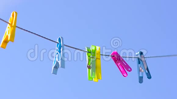 彩色衣夹在晾衣绳上迎风蓝天视频的预览图