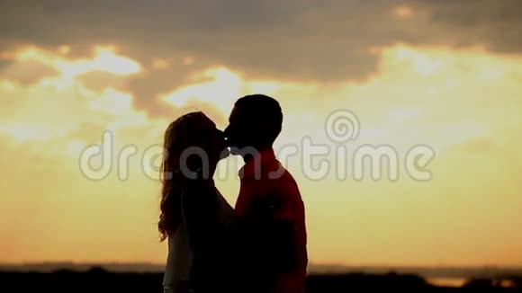 日落时的爱情剪影吻和拥抱浪漫视频的预览图