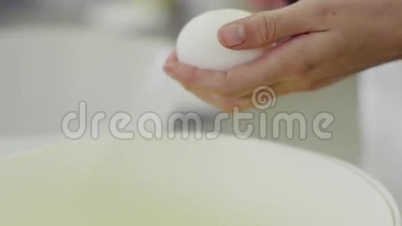 女性手打破鸡蛋将蛋黄与蛋白质分离特写镜头视频的预览图