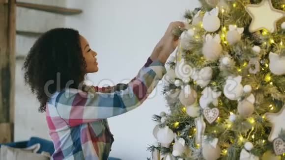 漂亮的非洲年轻女子在家装饰圣诞树准备庆祝圣诞节视频的预览图