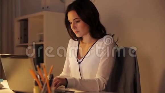 有笔记本电脑的女人在夜间办公室喝咖啡视频的预览图