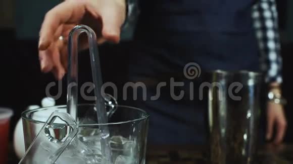 酒保把冰杯放在杯子里视频的预览图
