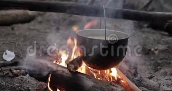 老复古营地索塞潘煮水汤准备在森林火灾夏季晚上火焰篝火视频的预览图