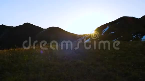 太阳从雪山后面升起与美丽的镜头耀斑紧密拍摄通过框架视频的预览图