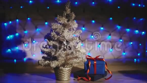 呈现在银色圣诞树下的蓝色花环背景下视频的预览图