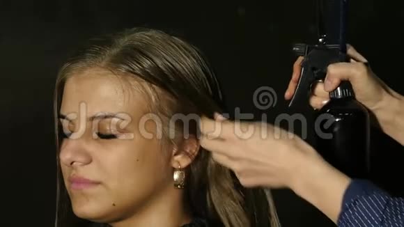 时尚的理发师把水溅在一个漂亮女人的头发上动作缓慢视频的预览图