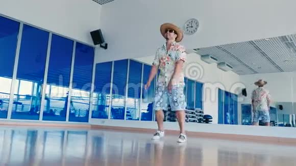 戴太阳镜戴帽子的滑稽男人在健身房跳舞视频的预览图