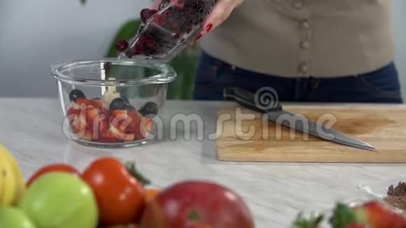把浆果移到玻璃碗里视频的预览图
