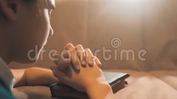 小女孩在夜里祈祷小女孩用手祈祷小女孩圣经在圣经中祈祷视频的预览图