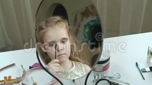 有红发的小女孩把睫毛膏涂在睫毛上照镜子化妆脸时尚时尚时尚化妆品视频的预览图
