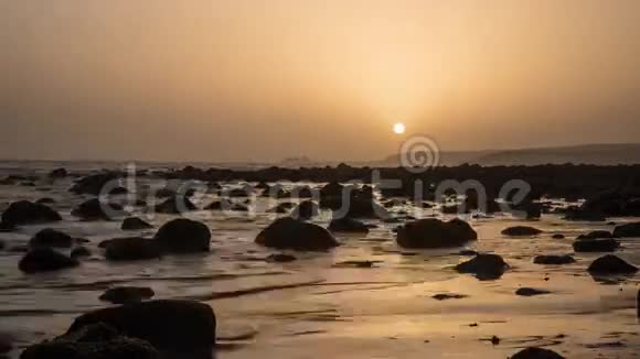 日落时海波带岩石的时间推移视频的预览图