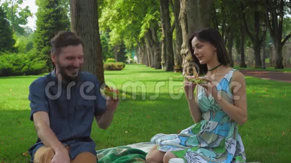 年轻夫妇拿着三明治在公园野餐视频的预览图