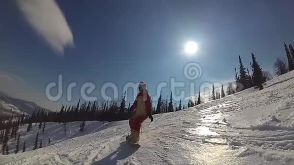 快乐的女孩在滑雪板上滑下斜坡视频的预览图